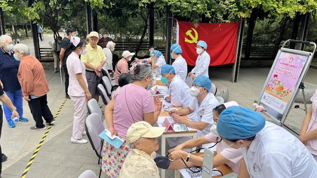 图为义诊现场医生为居民进行检诊